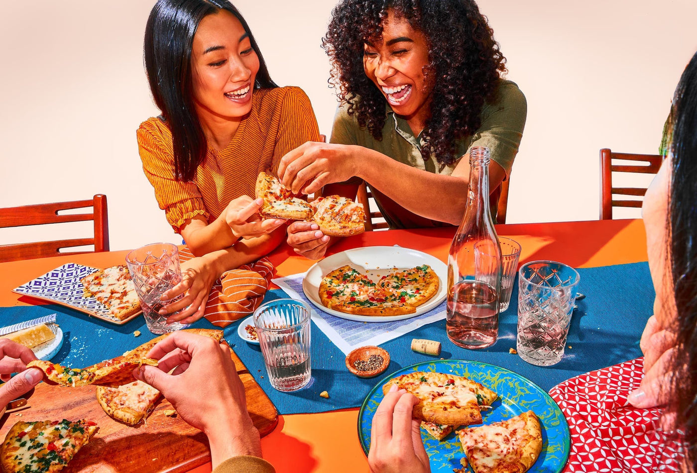 Friends enjoying Banza pizza with rosé